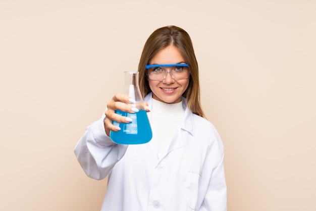 Junge blonde Frau über getrennter Wand mit einem wissenschaftlichen Reagenzglas