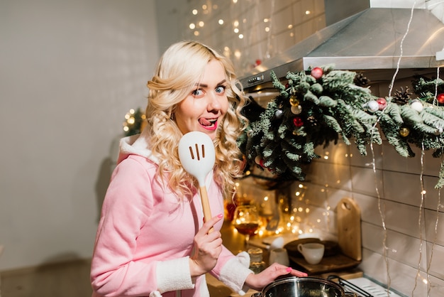 Junge blonde Hausfrau, die Weihnachtsessen in der Küche vorbereitet