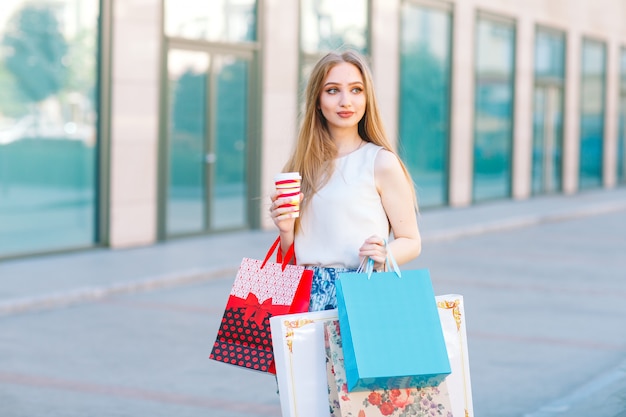 junge blonde Mädchen, mit Einkaufstüten aus dem Shop.