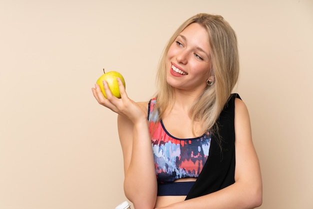 Junge blonde Sportfrau mit einem Apfel