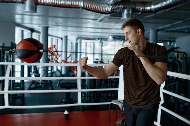 Junge Boxer trainieren mit Boxsack im Fitnessstudio