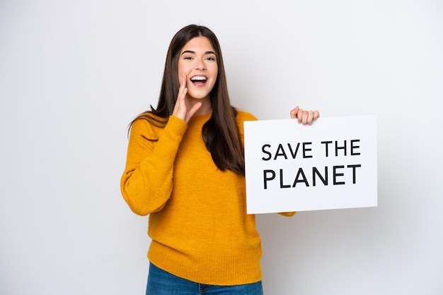 Junge Brasilianerin isoliert auf weißem Hintergrund, die ein Plakat mit dem Text Save the Planet hält und schreit