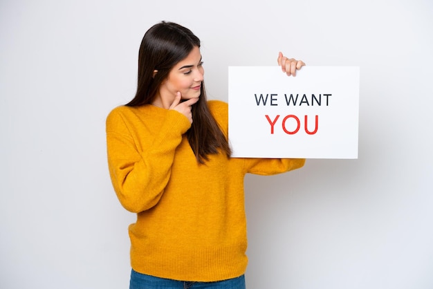 Junge Brasilianerin isoliert auf weißem Hintergrund mit We Want You Board mit fröhlichem Gesichtsausdruck