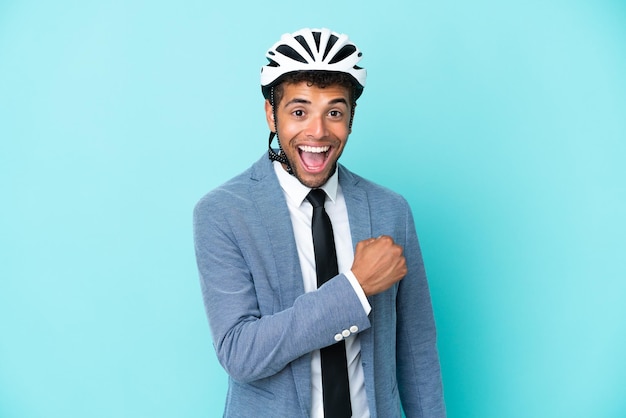 Junge brasilianische Geschäftsfrau mit Fahrradhelm auf blauem Hintergrund isoliert einen Sieg feiernd