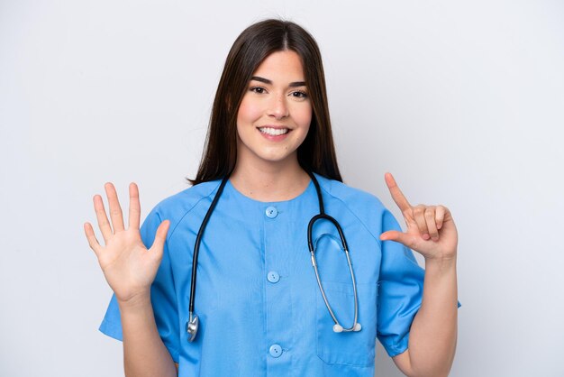 Junge brasilianische Krankenschwester isoliert auf weißem Hintergrund und zählt sieben mit den Fingern