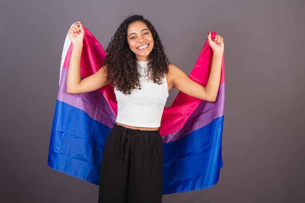 Junge brasilianische schwarze frau, die die bisexuelle flagge hisst bisexuelle frau lgbt lgbtq