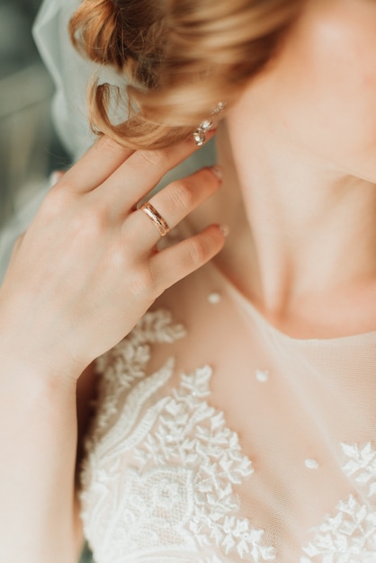 Junge Braut im weißen Hochzeitskleid zeigt Hand mit Ring