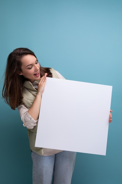 Junge brünette Frau zeigt Informationen auf weißem Bildschirm