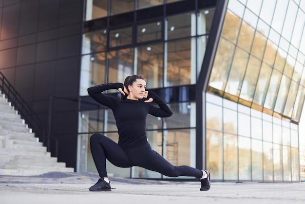 Junge Brünette in sportlicher Kleidung hat einen Fitnesstag im Freien in der Stadt