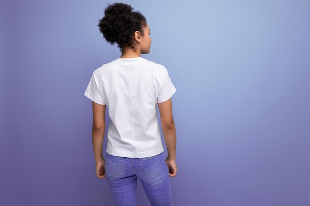 Junge brünette lateinamerikanische Frau in einem weißen T-Shirt mit einem Druckmodell steht mit dem Rücken
