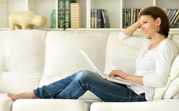 Junge Brunettefrau, die Laptop verwendet