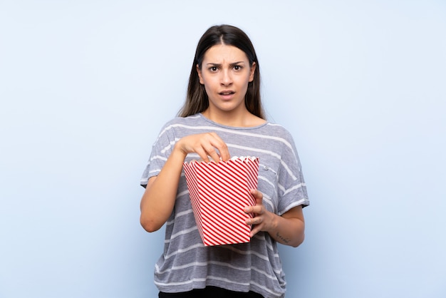 Junge Brunettefrau, die Popcorn isst