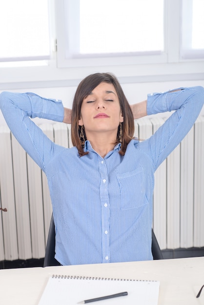 Junge Brunettefrau im blauen Hemd entspannt sich