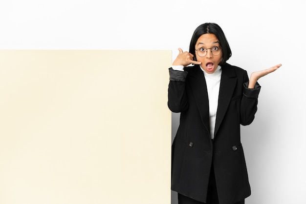 Junge Business-Mixed-Race-Frau mit einem großen Banner über isoliertem Hintergrund, die Telefongeste macht und zweifelt