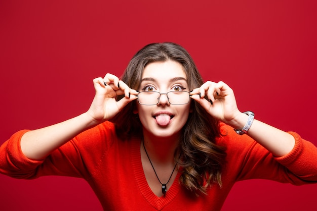 Foto junge charismatische frau gegen eine rote wand