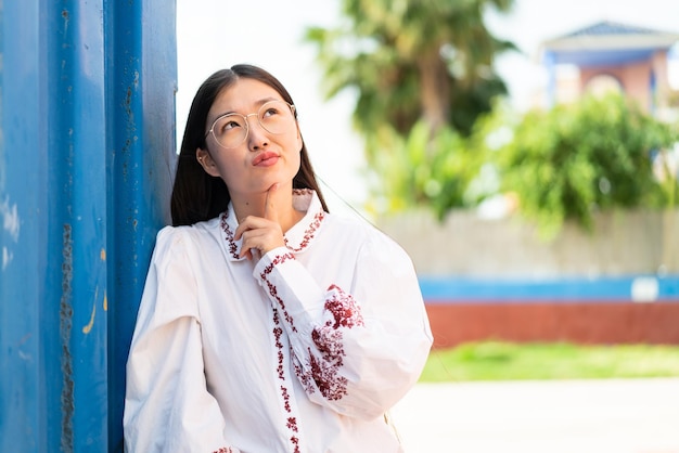 Junge Chinesin im Freien mit Brille und nachschlagen