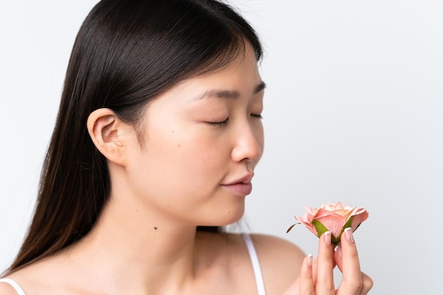 Junge Chinesin isoliert auf weißem Hintergrund mit Blumen Close up Portrait