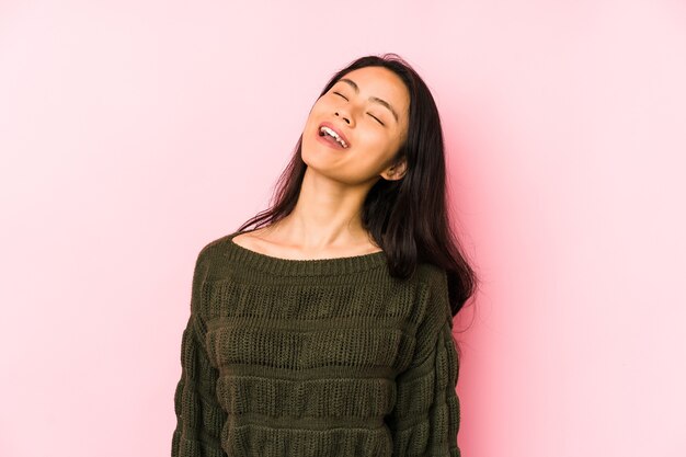 Junge chinesische Frau lokalisiert auf einem rosa Hintergrund entspannt und glücklich lachend, Hals gestreckt, der Zähne zeigt.