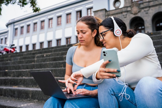 Junge College-Freunde, die auf dem Campus telefonieren