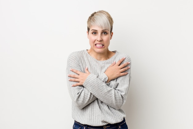 Junge curvy kaukasische Frau getrennt auf dem Weiß, das wegen der niedrigen Temperatur oder einer Krankheit kalt geht.