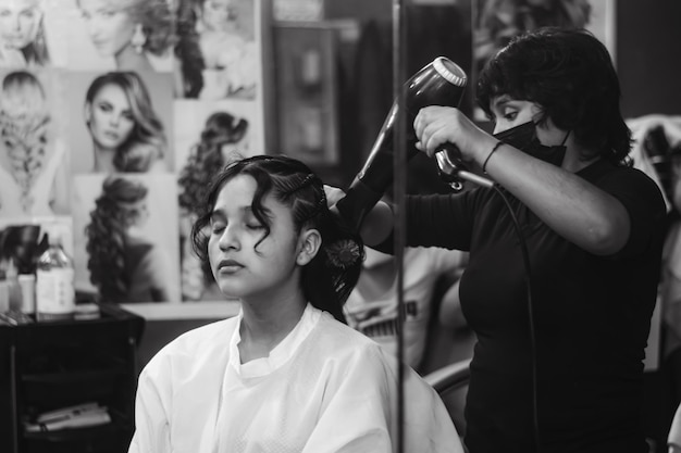 Junge Dame beim Schminken in einem Spa oder Friseursalon, Schwarz-Weiß-Farbfoto.