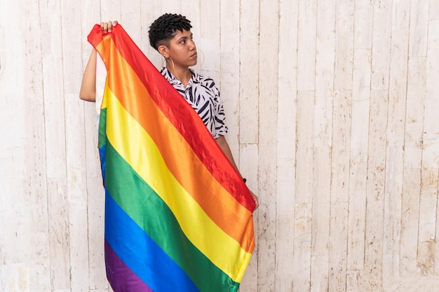 Junge Dame, die eine Gay-Pride-Flagge zur Unterstützung von Gay Pride schwenkt