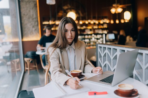 Junge Dame, die im Café im Internet surft