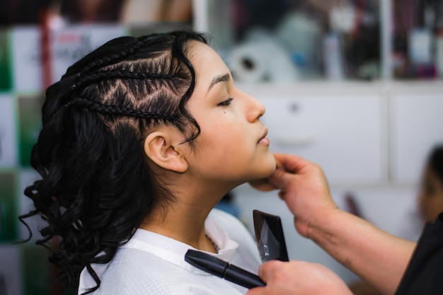 Junge Dame, die sich in einem professionellen Spa oder Friseursalon schminken und Haare machen lässt.