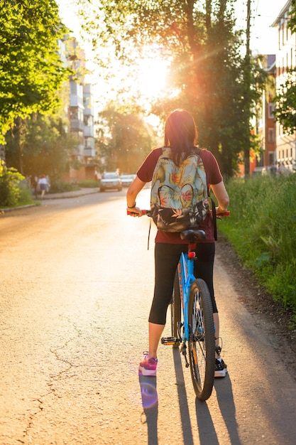 Foto junge dame mit fahrrad auf einer landstraße