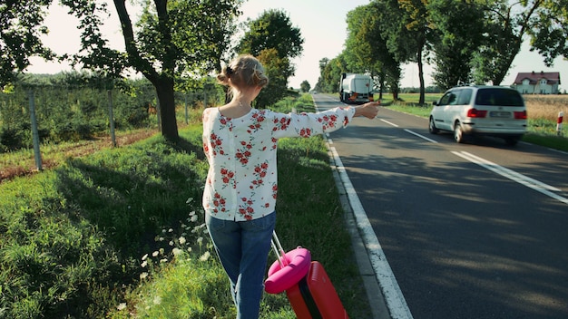 Junge Dame per Anhalter auf Landstraße.