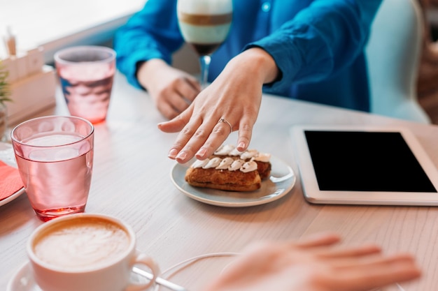 Junge Dame zeigt Freund im Café ihren Verlobungsring