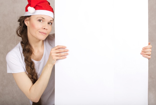 Junge Dame zwischen 30 und 40 Jahren mit Weihnachtsmannmütze