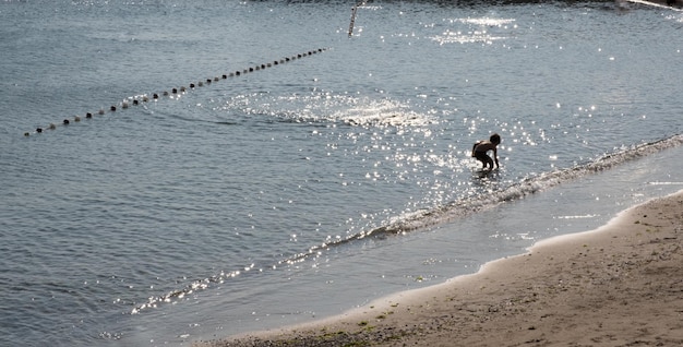 Junge, der am Meer steht