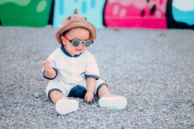 Foto junge, der auf dem boden am spielplatz sitzt