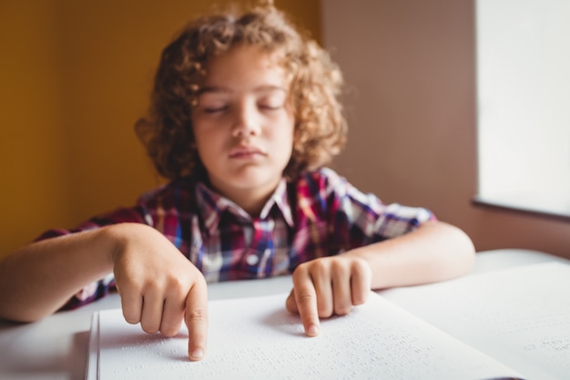 Junge, der Blindenschrift verwendet, um zu lesen