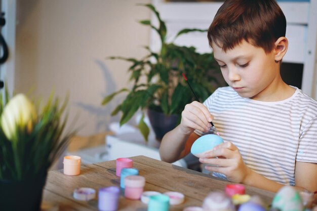 Junge, der Eier für Ostern färbt Bild mit selektivem Fokus