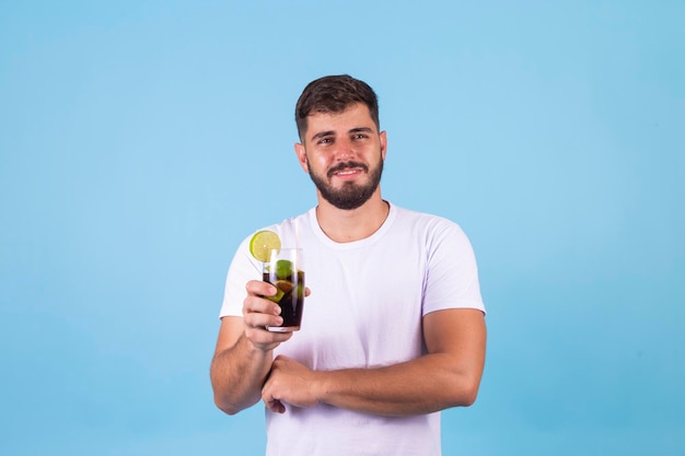 Junge, der eine Cola in einem Glas trinkt