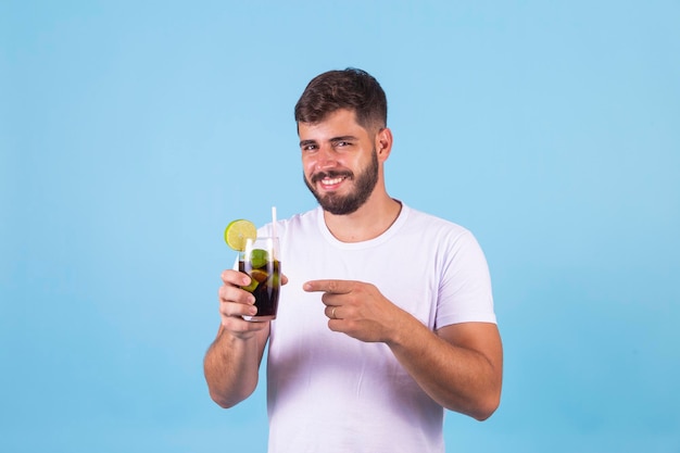 Junge, der eine Cola in einem Glas trinkt