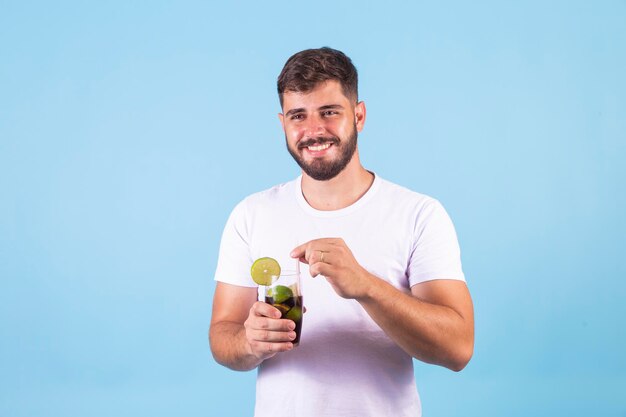 Junge, der eine Cola in einem Glas trinkt