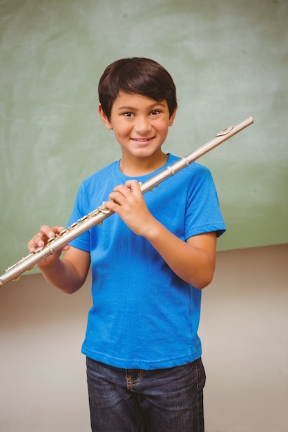 Junge, der Flöte im Klassenzimmer spielt