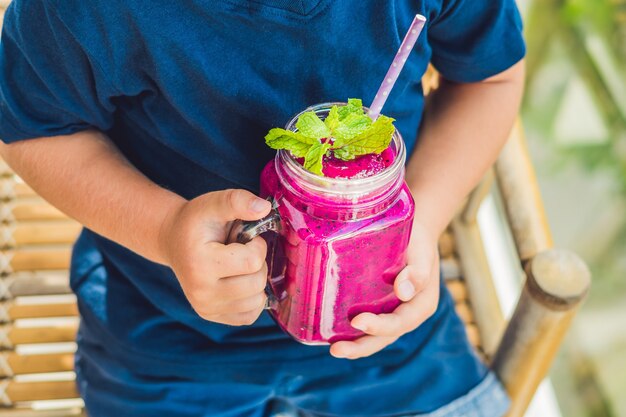 Junge, der Glas mit Drachenfrucht-Smoothie hält