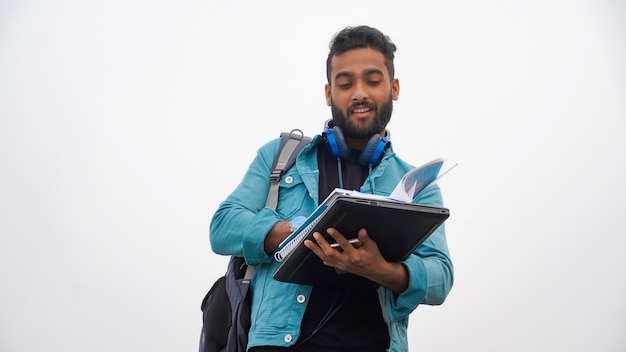 Junge, der im Notizbuch auf Weiß schreibt