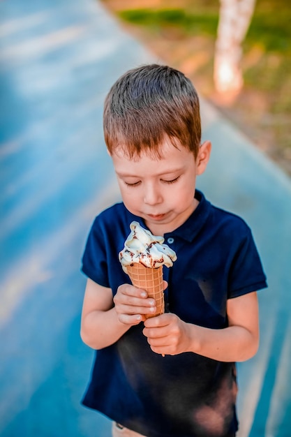 Junge, der im Sommer auf der Straße Eis isst