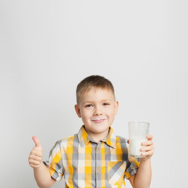 Junge, der in der Hand Glas Milch hält