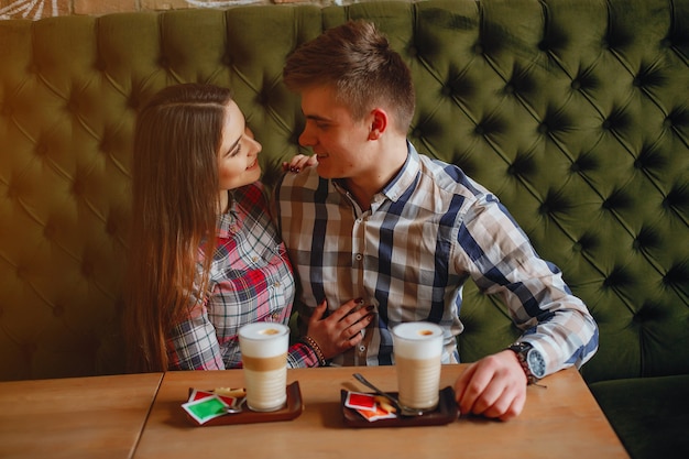Foto junge, der in einem café sitzt und kaffee mit seiner freundin trinkt