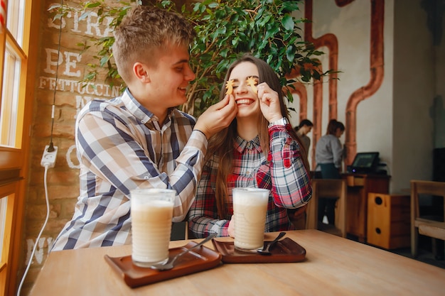 Junge, der in einem Café sitzt und Kaffee mit seiner Freundin trinkt