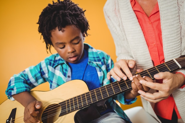 Junge, der lernt, wie man Gitarre spielt