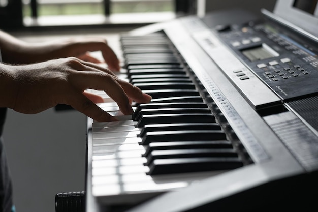 Junge, der lernt, zu Hause Klavier zu spielen Detailaufnahme der Hände eines Mannes, der ein Lied auf seinem Synthesizer spielt