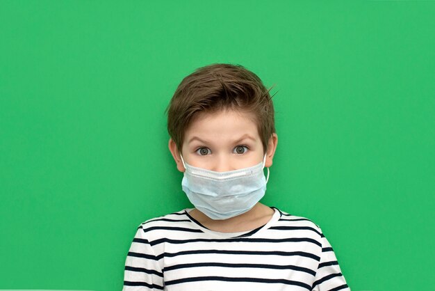 Junge, der medizinische Maske trägt, die während des Coronovirus isoliert wird.