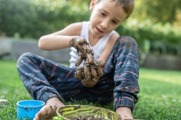 Junge, der mit Schlamm spielt